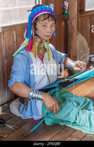 INLE, MYANMAR - 28. NOVEMBER 2016: Kayan Langhalsfrau webt in einem Workshop am Inle Lake, Myanmar, einen Stoff Stockfoto