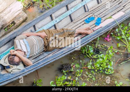 INLE, MYANMAR - 28. NOVEMBER 2016: Einheimischer schläft in einem Boot am Inle See, Myanmar Stockfoto