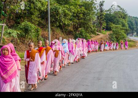 HSIPAW, MYANMAR - 1. DEZEMBER 2016: Junge buddhistische Nonnen gehen in einem Dorf in der Nähe von Hsipaw, Myanmar, zur Almosen Stockfoto