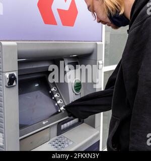 Kingston upon Thames London, Großbritannien, Mai 04 2021, junger Mann zieht Bargeld von EINEM NatWest Geldautomaten ab Stockfoto