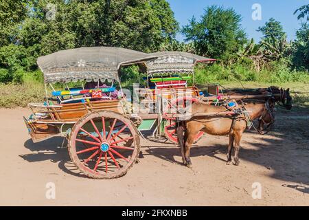 INWA, MYANMAR - 5. DEZEMBER 2016: Pferdewagen warten auf Touristen in der antiken Stadt Inwa Ava in der Nähe von Mandalay, Myanmar Stockfoto