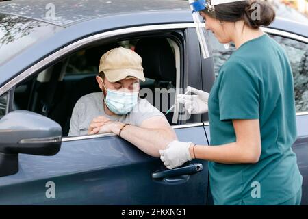 Krankenschwester, die eine Spritze zur Verabreichung eines Impfstoffs verwendet Stockfoto