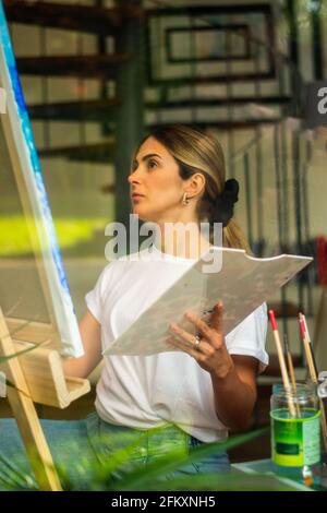 Junge blonde Mädchen auf den Knien Blick auf die Leinwand In der virtuellen Klasse Stockfoto