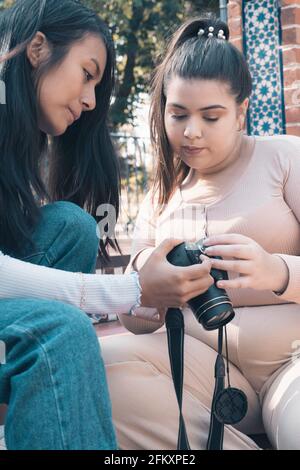 Zwei junge Freunde, die sich die Fotos ansehen, die kürzlich in einer Fotosession aufgenommen wurden. Stockfoto