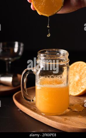 Tropfen Orangensaft fallen in ein Glas Stockfoto