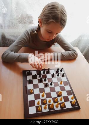 Das Mädchen denkt beim Schachspielen Stockfoto