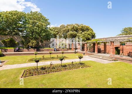 Rote Backsteinpergola und formeller Garten in Connaught Gardens in Sidmouth, einer kleinen beliebten Küstenstadt an der Südküste in Devon, Südwestengland Stockfoto