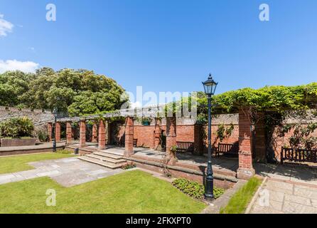 Rote Backsteinpergola und formeller Garten in Connaught Gardens in Sidmouth, einer kleinen beliebten Küstenstadt an der Südküste in Devon, Südwestengland Stockfoto