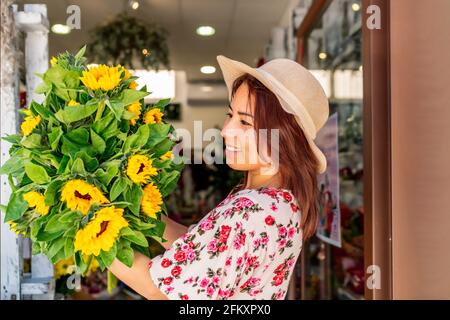 Schöne Frau mit einem Strauß Sonnenblumen in ihren Händen Stockfoto