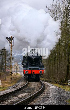 Historische Dampfeisenbahn (Lok), die Rauchwolken bläst, auf einer landschaftlich reizvollen historischen Eisenbahn (Signalschild, Menschen an Bord) - KWVR, Yorkshire, England, Großbritannien. Stockfoto