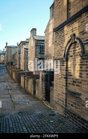 Hintergasse einer Reihe von Reihenhäusern im Modelldorf Saltaire von Sir Titus Salt, in der Nähe von Bradford, West Yorkshire, England, Großbritannien Stockfoto