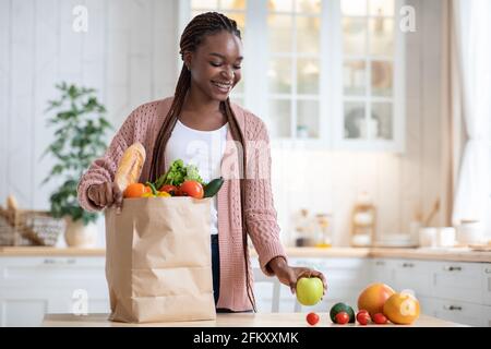 Black Lady Auspacken Papiertüte Mit Gemüse Und Obst Nach Lebensmittelgeschäfte Stockfoto