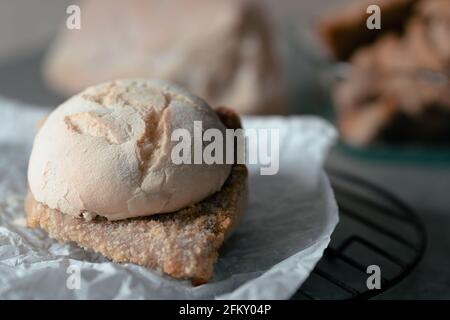 Auf einem Grill befindet sich ein Sandwich mit einem mailändischen Schnitzel. Es ist bereit, eingepackt zu werden. Stockfoto