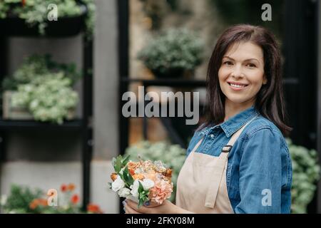 Modernes kleines Unternehmen mit Pflanzen in der Stadt im Freien, Eigentümer und Verkäufer bei der Arbeit Stockfoto