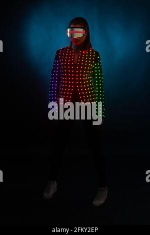 Mädchen in LED-Anzug auf schwarzem Hintergrund Stockfoto