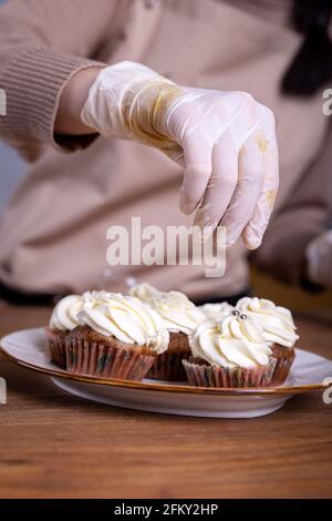 Cupcakes mit der Creme Nahaufnahme mit den Händen der machen Koch Stockfoto