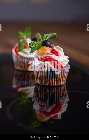 Cupcakes mit frischen Beeren und Minze aus nächster Nähe Stockfoto