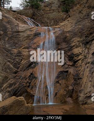Seven Falls Colorado Springs Slow-Motion-Wasserfall, der durch Dürre und die negativen Auswirkungen des Klimawandels an der Felswand mit niedrigem Wasserstand herabstürzt. Stockfoto