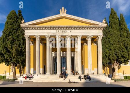 Athen, Attika, Griechenland. Fassade des berühmten neoklassizistischen Gebäudes Zappeion Hall im Zentrum der Stadt Athen. Die Leute sitzen auf der Treppe Stockfoto