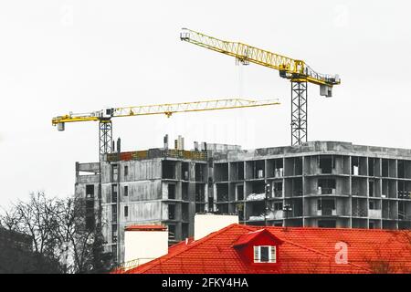 Bau von Industriekranen im Turm vor Ort. Gebäudeplanung, Entwicklung und Arbeit bei der Schaffung von städtischer Architektur. Stockfoto