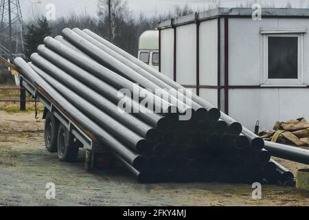 Ein Stapel von Polyethylenrohren, Industriematerialien, die auf einer Baustelle beladen und gelagert werden. Stockfoto