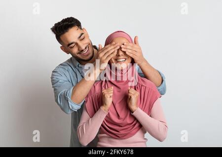 Anhänglicher islamischer Ehemann, der seine muslimische Frau in Hijab überraschte Stockfoto