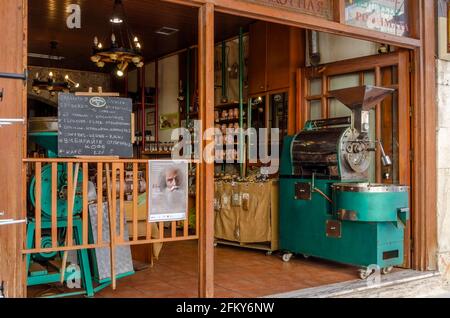 Heraklion, Kreta, Griechenland. Café-Bar auf dem traditionellen zentralen Markt in Heraklion. Alte Kaffeeröstermaschine. Traditionelle kretische Waren Stockfoto
