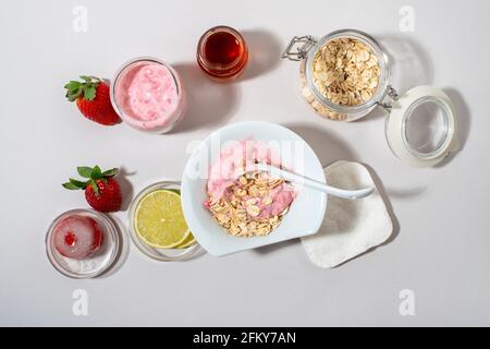 Hausgemachte Erdbeer Gesichtsmaske Zutaten: Erdbeere, Joghurt, Honig, Zitrone, Haferflocken. DIY hausgemachte natürliche Hautpflegeprodukte. Draufsicht. Stockfoto