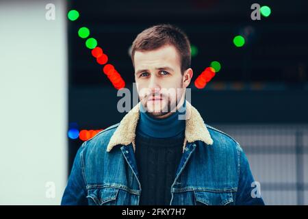 Nahaufnahme eines brutalen Mannes in Denim-Jacke Stockfoto