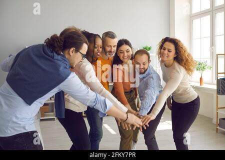 Eine Gruppe von glücklich motivierten, vielfältigen Geschäftsleuten, die sich zusammenschließen Büromeeting Stockfoto