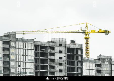 Turm gelb Baukran baut neue Beton und Zement Stadtgebäude auf der Baustelle. Stockfoto