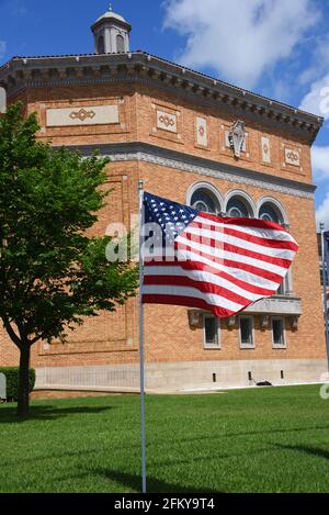 First Baptist Church, in El Dorado, Arkansas, fliegt die amerikanische Flagge vor ihrer Kirche. Der Himmel ist sonnig und blau. Stockfoto