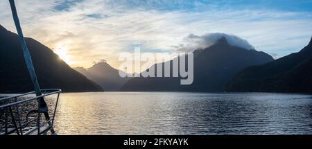 Sonne geht über Doubtful Sound auf, Wolken hängen tief auf den Bergen, Südinsel von Neuseeland Stockfoto