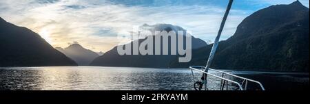 Sonne geht über Doubtful Sound auf, Wolken hängen tief auf den Bergen, Südinsel von Neuseeland Stockfoto