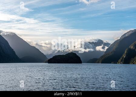 Sonne geht über Doubtful Sound auf, Wolken hängen tief auf den Bergen, Südinsel von Neuseeland Stockfoto