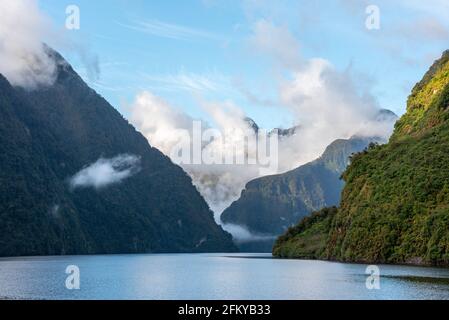 Sonne geht über Doubtful Sound auf, Wolken hängen tief auf den Bergen, Südinsel von Neuseeland Stockfoto