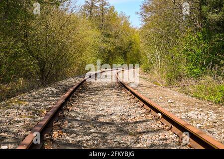 Eingleisige Abzweigung einer Eisenbahn durch das ländliche Gebiet. Keine Personen. Stockfoto