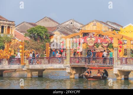 Hoi an, Vietnam - 6 2019. März: Touristen und einheimische Vietnamesen besuchen die Brücke der Lichter (CAU Den Long), über den Thu Bon Fluss in Hoi an einem alten Schlepptau Stockfoto