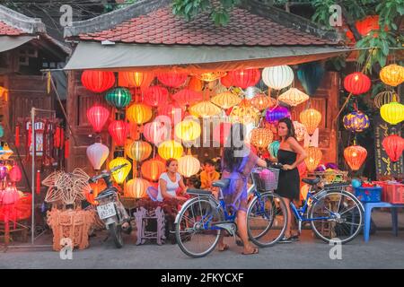 Hoi an, Vietnam - März 6 2019: Touristen besuchen einen lokalen vietnamesischen Straßenhändler, der bunte, traditionelle Straßenlaternen in Hoi an, Vietnam verkauft. Stockfoto