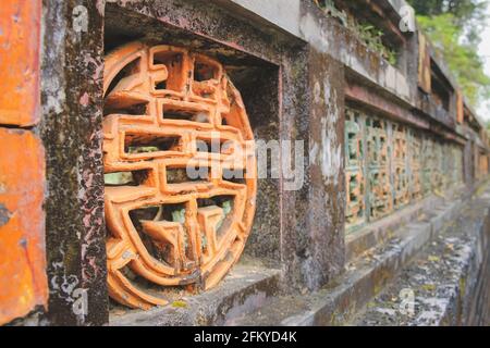 Nahaufnahme eines Motivs des chinesischen Symbols für Langlebigkeit entlang einer alten Steinmauer in der historischen kaiserlichen Stadt Zitadelle Hue, Vietnam Stockfoto