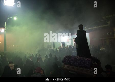 Nachts nimmt die Semana Santa-Prozession in Antigua eine geheimnisvolle, spirituelle Atmosphäre an, während Räucherrauch die Luft um eine beleuchtete Ananda füllt. Stockfoto