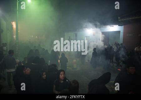 Weihrauch füllt die Straßen nachts, während die Menschen an einer Semana Santa Prozession während der Karwoche in Antigua, Guatemala, teilnehmen. Stockfoto