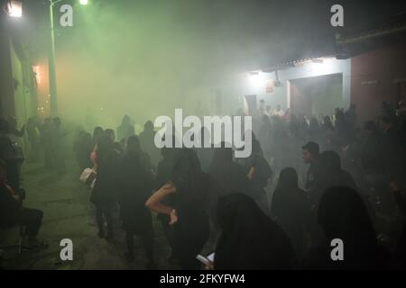 Weihrauch füllt die Straßen nachts, während die Menschen an einer Semana Santa Prozession während der Karwoche in Antigua, Guatemala, teilnehmen. Stockfoto