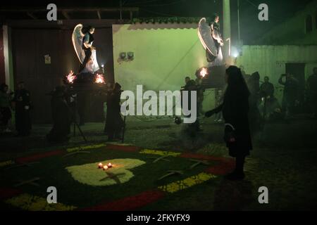 Beleuchtete Engelsandas, getragen von hingebungsvollen Märschen, schaffen eine ätherische Atmosphäre während der nächtlichen Semana Santa Prozession in Antigua, Guatemala. Stockfoto