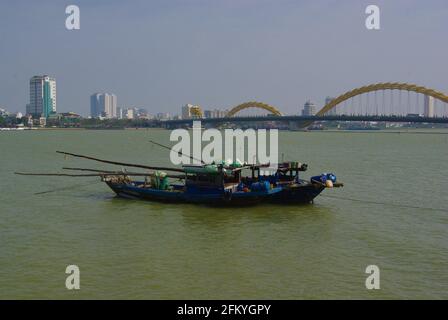 Arbeitsboote mit Drachenbrücke am Han-Fluss, Da Nang, Vietnam, Asien Stockfoto