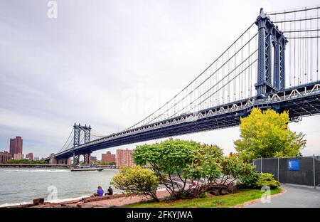 New York City, USA - Juli 16 2014: Die Manhattan Bridge vom Brooklyn Bridge Park aus gesehen, einem Uferpark am East River in New York City. Stockfoto