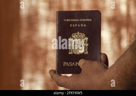 Hand eines Mannes mit einem Pass im Vordergrund Stockfoto