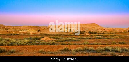 Nächtliches Bannerpanorama der Opalgräberstadt Coober Pedy in Australien bei Dämmerung. Opal Hauptstadt der Welt in Südaustralien. Breakaways Reserve Stockfoto