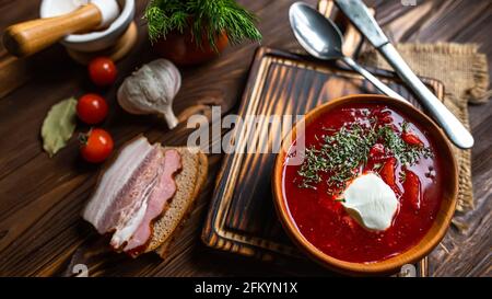 Traditionelle ukrainische Russischen Borschtsch mit weißen Bohnen auf die Schüssel. Platte von Rot Rote Beete Suppe Borschtsch auf Schwarz rustick Tabelle. Rote-bete-Suppe Ansicht von Oben. Stockfoto