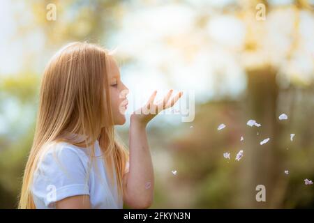 Hübsches achtjähriges Mädchen draußen im Sonnenschein lächelnd Stockfoto
